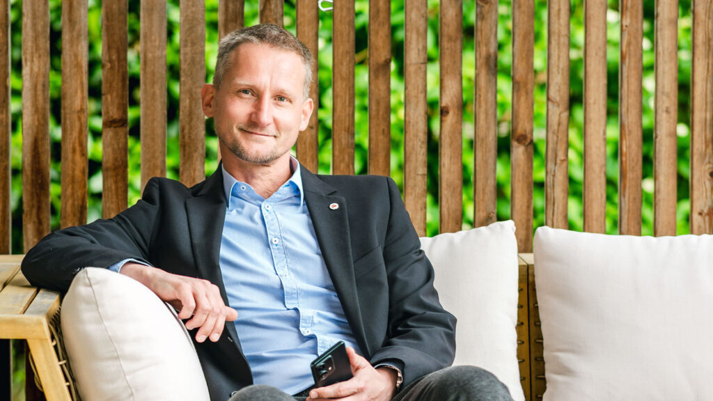 Mag. Alexander Haas von haas finance sitzt auf einem Loungesofa.